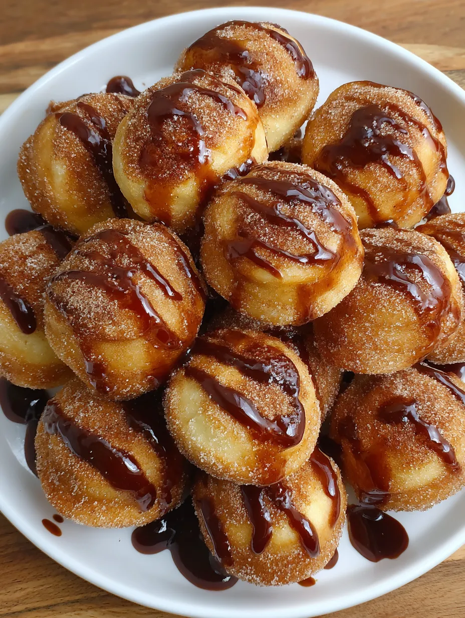 A plate of doughnuts with chocolate sauce.
