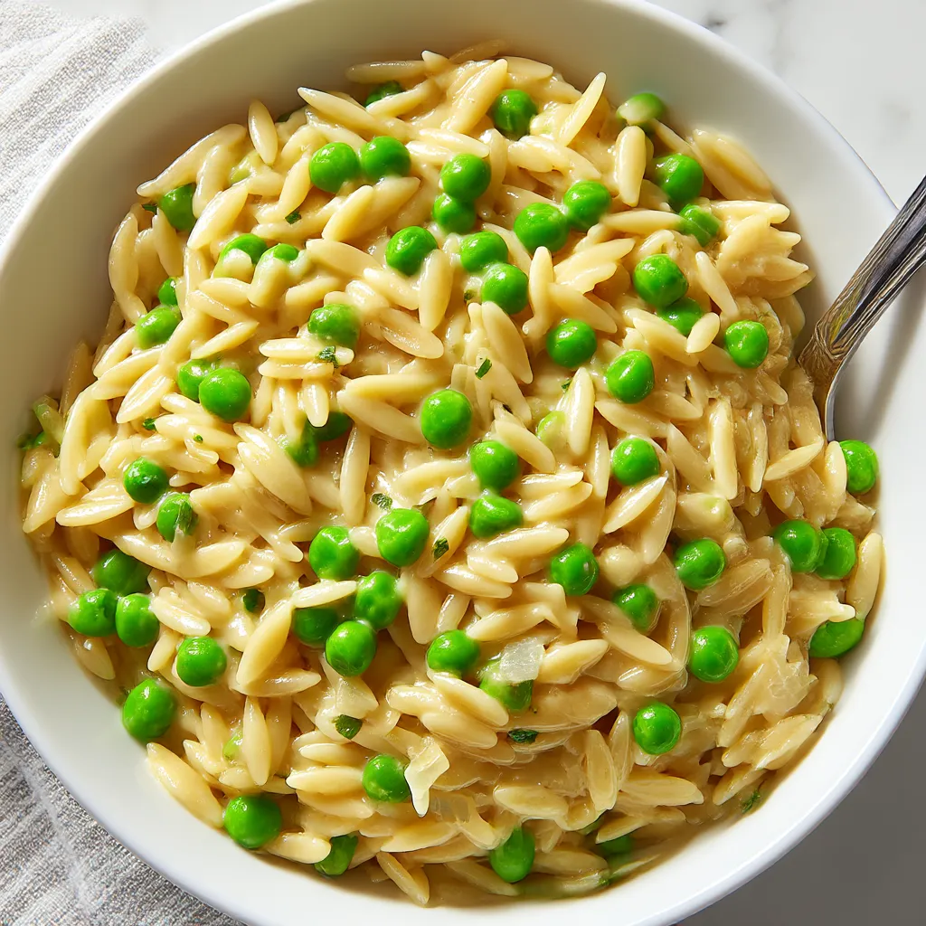 Creamy pasta with peas and shredded parmesan in a serving bowl.