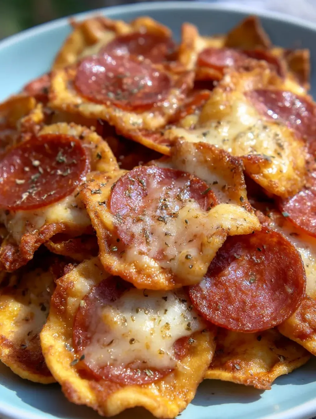 A bowl piled with 2 ingredient pizza chips, made from cheese and pepperoni.
