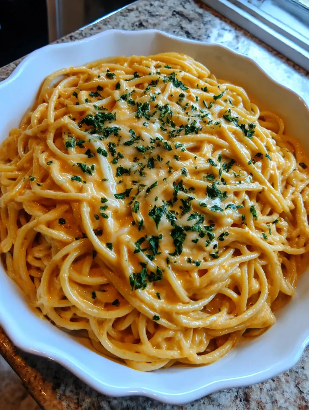 A white plate served with a helping of Cheesy Garlic Parmesan Spaghetti.