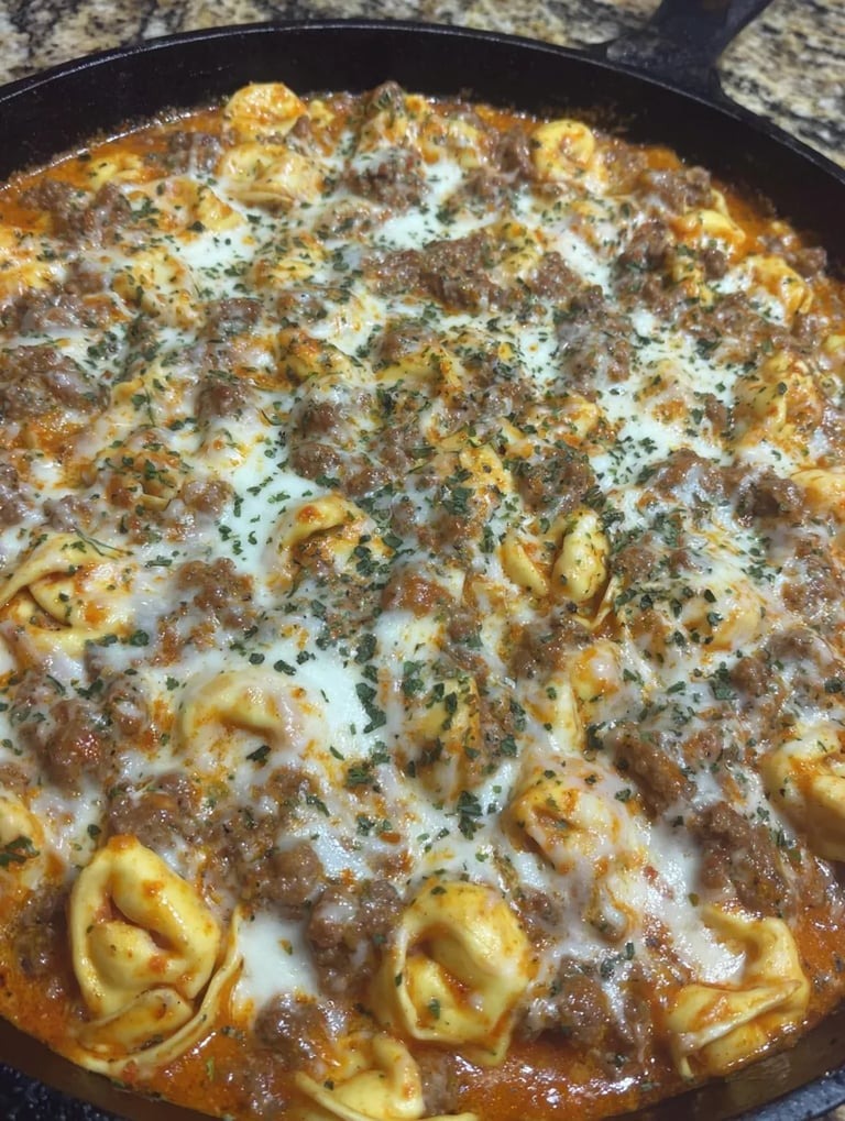 A bowl full of pasta and beef sitting right in the middle of the image.