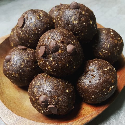 Chocolate covered black balls on a wooden tray.