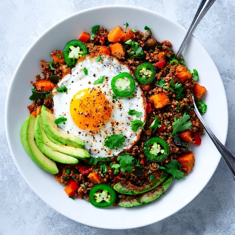Big bowl of Tex-Mex Potato Hash with a fried egg sitting on top.