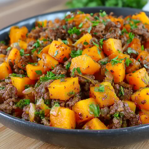 A bowl piled high with beef and sweet potato hash.