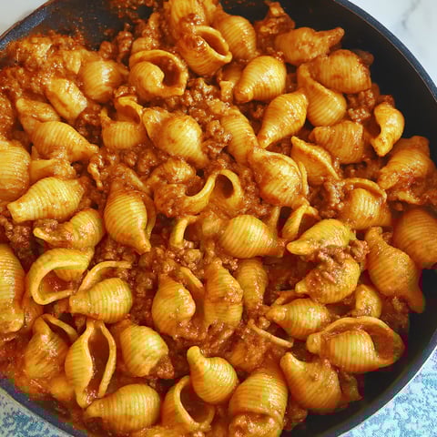 Pasta bowl topped with saucy ground beef.
