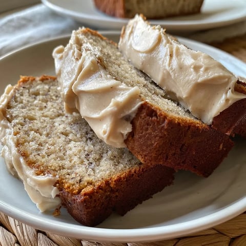 A white plate holding two slices of toasted bread spread with Nutella.
