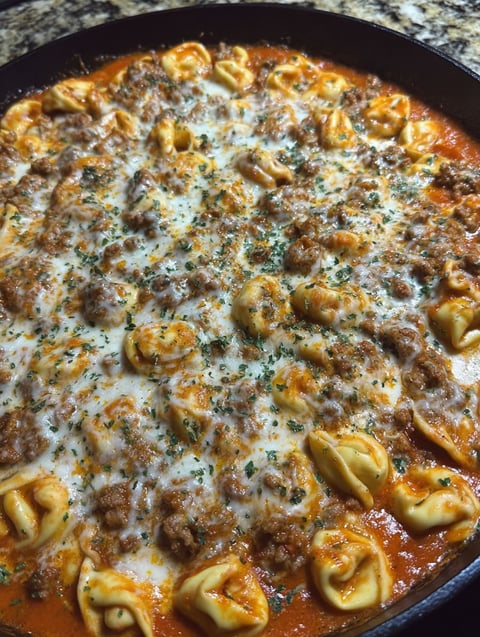 A bowl of pasta and beef.