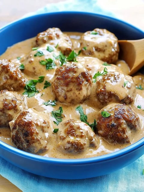 A bowl of meatballs in a creamy sauce.